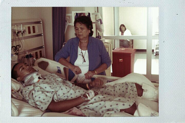 mike pictured in hospital bed with a neck brace after his accident